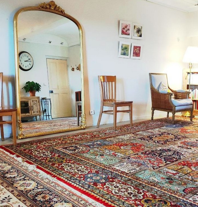 Salon lumineux du 3 Mirmande avec grand miroir doré et tapis persan
